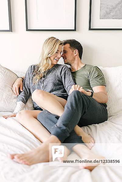 Couple relaxing on bed  legs entwined