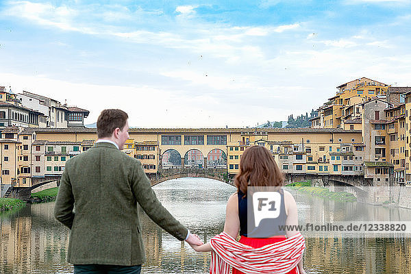 Young couple looking at Ponte Vecchio the Old Bridge Florence Toscana Italy