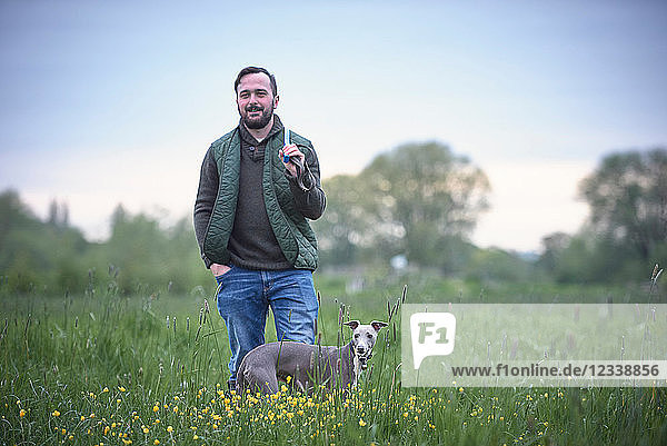 Junger Mann mit seinem Hund im Feld  Porträt