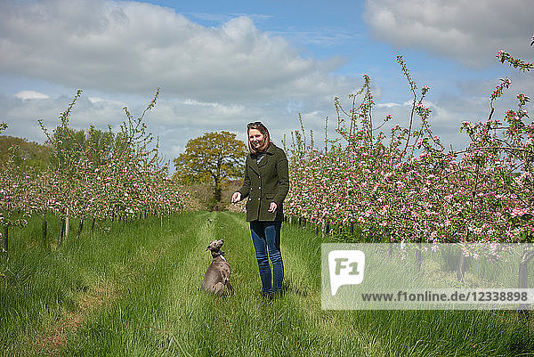 Woman and her dog in blossoming orchard  portrait