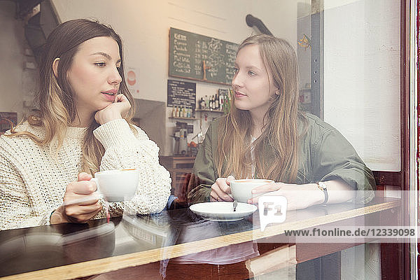 Young women chatting over coffee in cafe