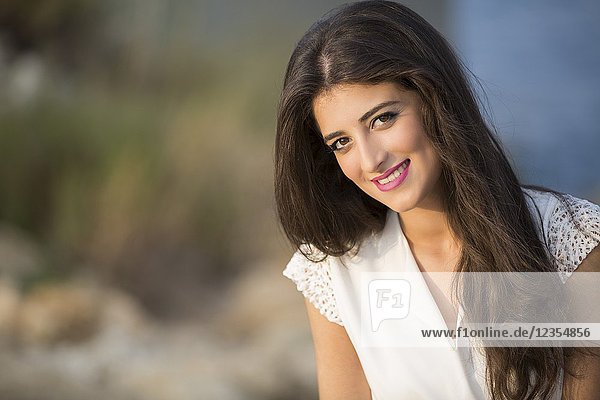 Portrait of a beautiful young woman smiling outdoors.