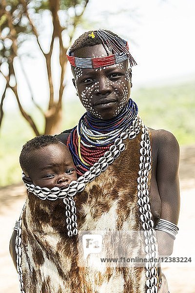 Junge Frau mit Kleinkind in traditioneller Kleidung aus Ziegenleder  Stamm der Karo  Region der südlichen Nationen und Völker  Äthiopien  Afrika