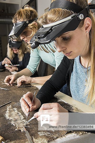 Restaurierungsatelier  Frauen  Restauratoren restaurieren geliehenen Schal auf Arbeitstisch in Atelier  München  Bayern  Deutschland  Europa
