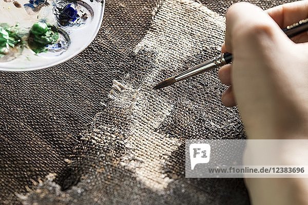 Restaurierungsatelier  Restauratorin  patiniert das eingewebte Leinenstück von Hand mit Pinsel und Farbe  München  Bayern  Deutschland  Europa