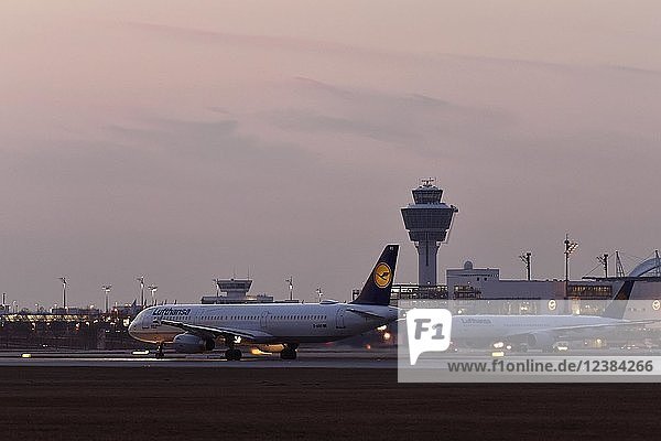 Lufthansa A321-100 Start auf der Südbahn Abenddämmerung hinten Tower und Terminal 2 Flughafen München Oberbayern Deutschland Europa