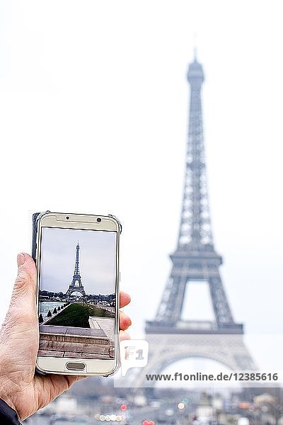 Frau fotografiert den Eiffelturm mit Smartphone, Paris, Ile De France, Frankreich, Europa