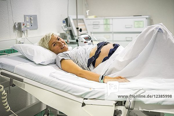 Schwangere Frau mit ctg zur Aufzeichnung des fötalen Herzschlags und der Uteruskontraktionen