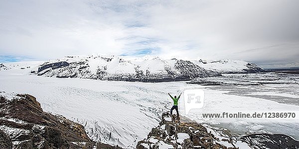 Wanderer streckt die Arme hoch  Blick auf Gletscherzunge  Gletscher Skaftafellsjökull  Vatnajökull Nationalpark  Südisland  Island  Europa