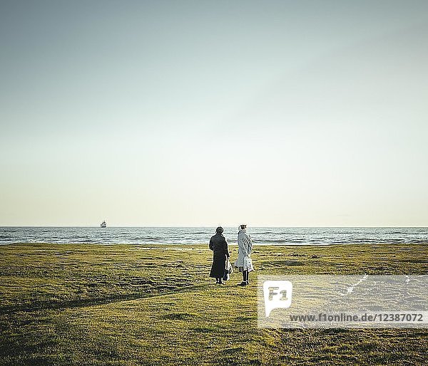 Two women standing at the coast looking at the horizon  black Sea coast  near Okhamchira  Abkhazia  Georgia  Asia