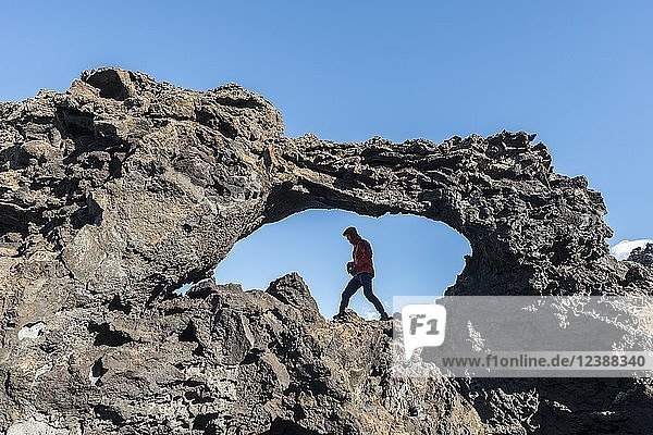 Mann in einem Felsbogen  Vulkanlandschaft  Vulkangebiet Krafla  Nationalpark Dimmuborgir  Mývatn  Island  Europa