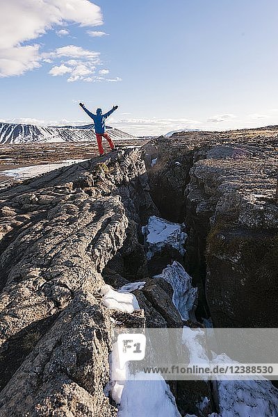 Der Mensch steht am Kontinentalgraben zwischen nordamerikanischer und eurasischer Platte  Mittelatlantischer Rücken  Rift Valley  Silfra Rift  Krafla  Nordisland  Island  Europa