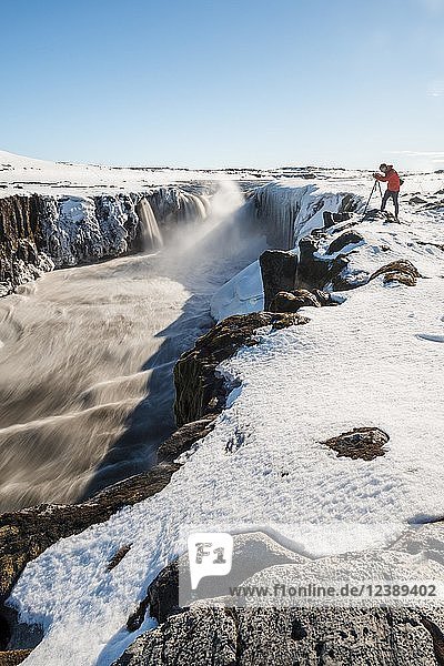 Photographing man at the edge of the Selfoss waterfall in winter  gorge  northern Iceland  Iceland  Europe