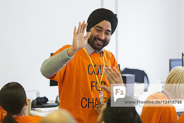 Happy hackers high-fiving  coding for charity at hackathon