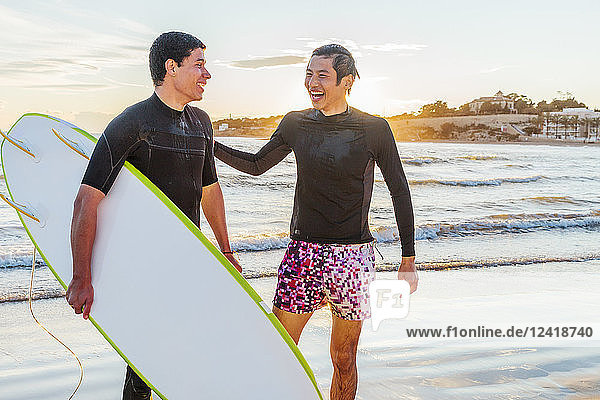 Happy male surfers on ocean beach