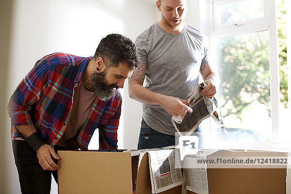 Male gay couple packing  moving out