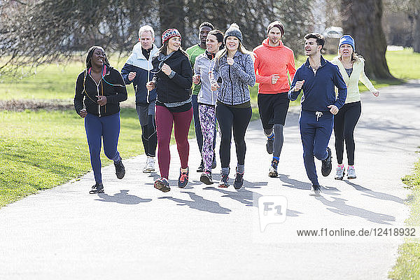Runner friends running in sunny park