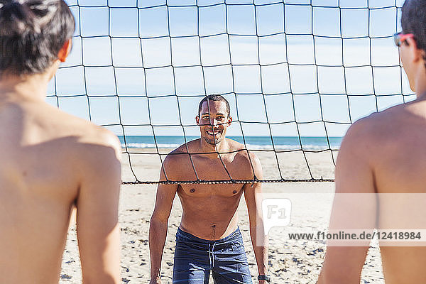 Portrait confident man playing beach volleyball on sunny beach