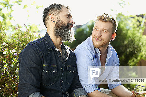 Male gay couple talking in garden