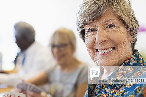 Portrait smiling  confident senior woman playing cards with friends