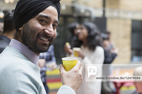 Portrait smiling man in turban drinking  enjoying party