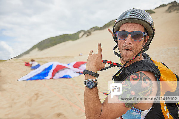 Portrait confident  carefree male paraglider on beach
