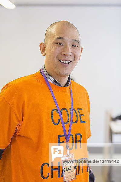 Portrait confident hacker coding for charity at hackathon