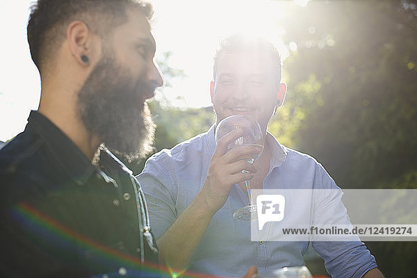 Male gay couple drinking wine and talking