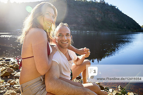 Portrait affectionate  carefree couple holding hands at sunny summer lake
