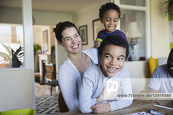 Portrait happy mother and sons at dining table