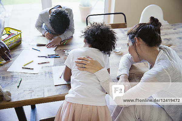 Mother and children coloring at dining table