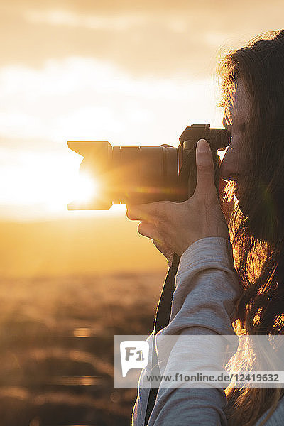Iceland,  female fotographer at sunset