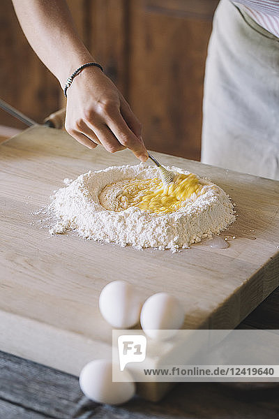 Woman preparing pasta dough  flour and eggs