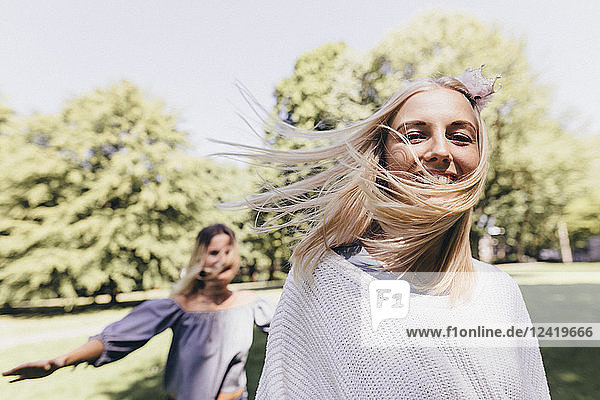 Portrait of two happy young women running in a park