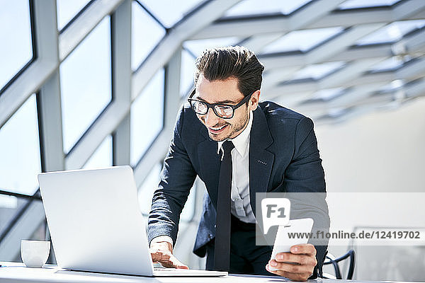 Smiling businessman working at desk in modern office