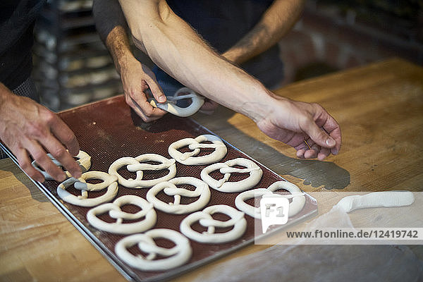 Bakers in bakery preparing fresh pretzls