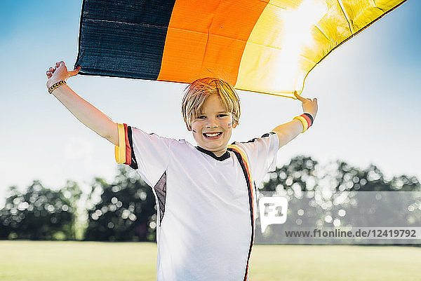 Boy  enthusiastic for soccer world championship  waving German flag