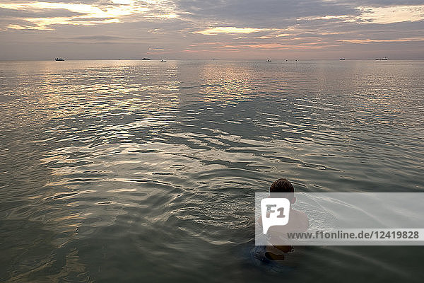 Thailand  boy swimming in the at sunset
