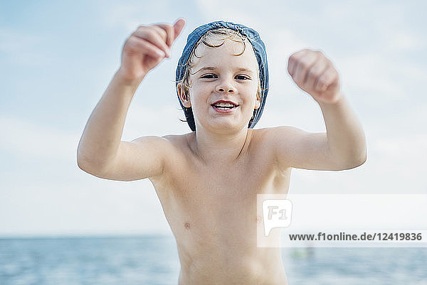 Portrait of happy boy wearing a cap at the sea