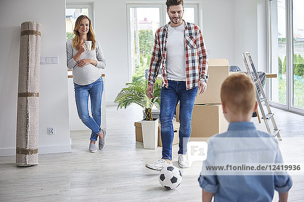Family playing football in new flat