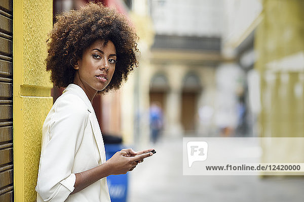 Portrait of waiting young woman with cell phone