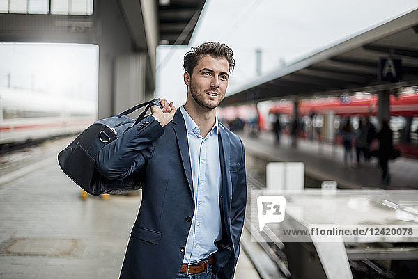Smiling businessman with bag at the platform