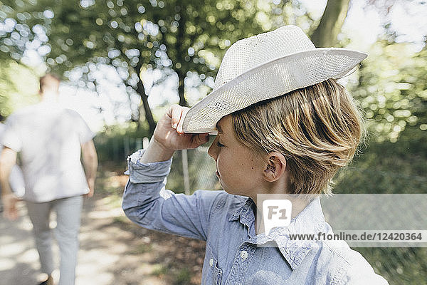Boy wearing a hat on forest path