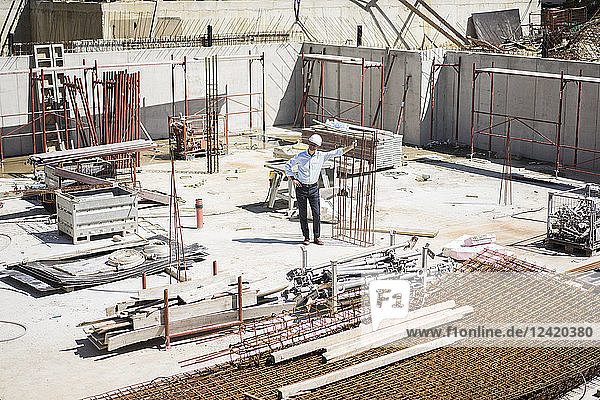 Man wearing hard hat on construction site looking around