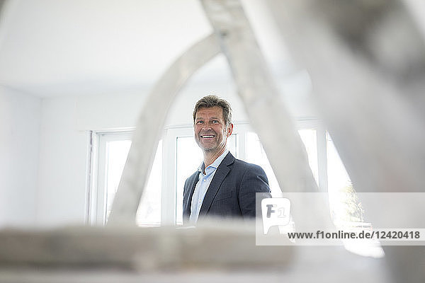 Portrait of smiling man in suit in building under construction