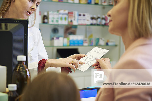 Pharmacist advising woman in pharmacy