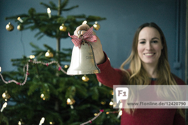 Smiling woman showing silver Christmas bell