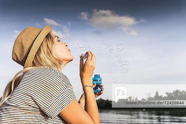 Blond woman blowing soap bubbles