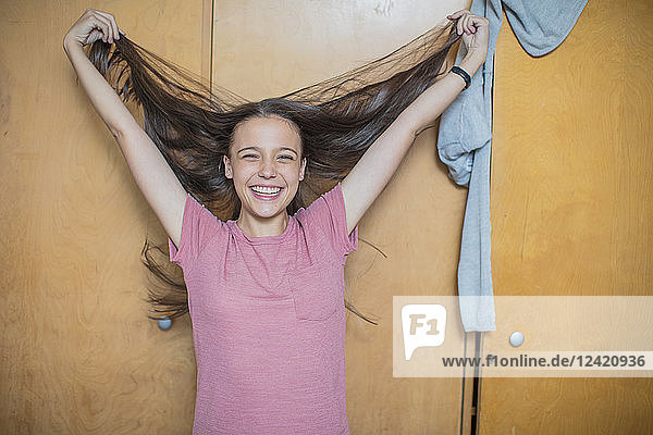 Portrait of carefree teenage girl playing with her hair