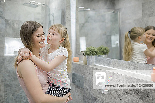 Little girl embracing her mommy in bathroom